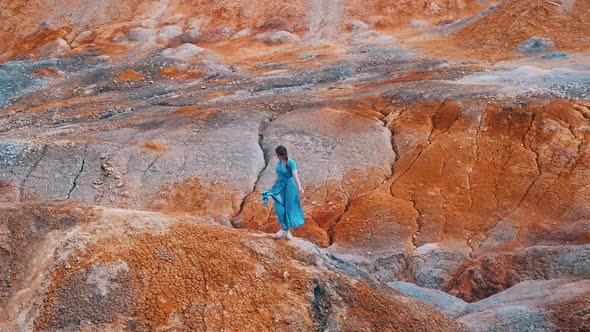 Young Woman Traveler Standing on an Orange Clay Mountains