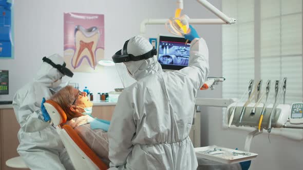 Doctor in Protection Suit Using Drilling Machine During Examining