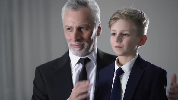 Handsome Grandfather Proud of Little Grandson, Preparing for Important Event