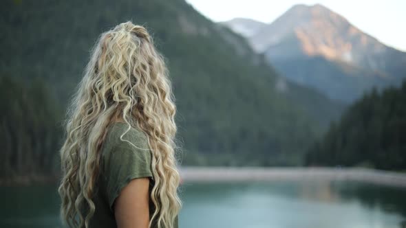 Slow Motion Shot of a happy beautiful blonde female overlooking a gorgeous scene in the mountains.