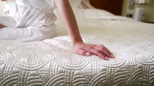 Girl's Hand on the Made Bed