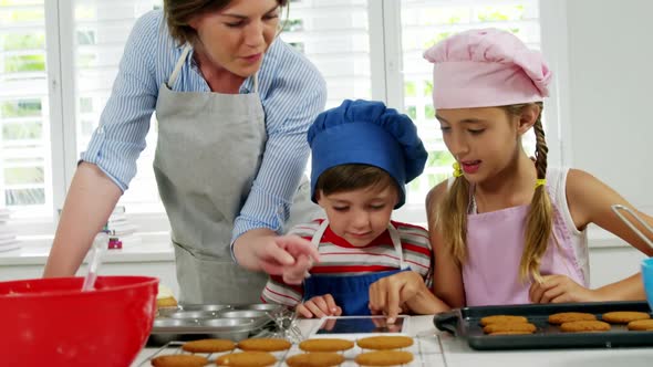 Mother and children making cookies in kitchen