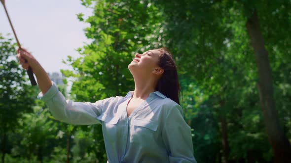 Smiling Woman Playing Badminton in Park