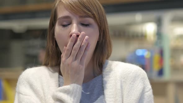 Tired Young Woman Yawning in Cafe Indoor