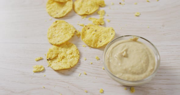 Video of crisps and cheese dip on a wooden surface