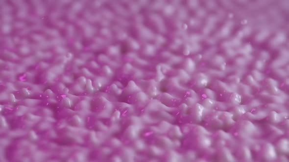 Macro Shot of Vibrating Spherical Drops of Purple Milk