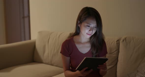 Woman use of tablet computer at night