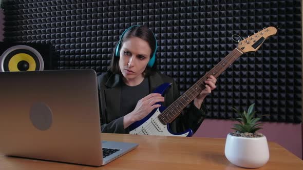 Female Learning Play Guitar at Home Using Online Lessons