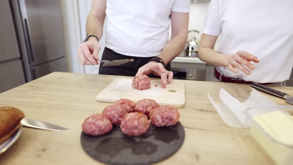 Couple Praparing Meat Burgers In The Kitchen