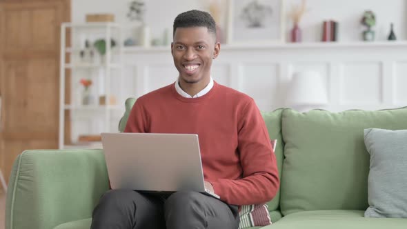 African Man Shaking Head as Yes Sign while using Laptop in Office