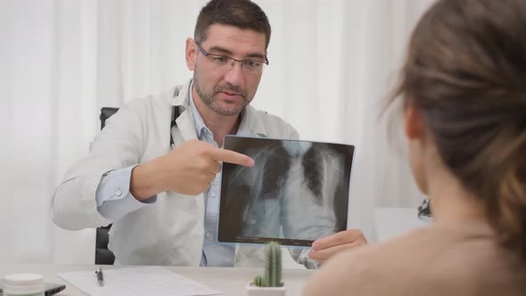 Doctor Explaining X-ray Result To Female Patient In The Hospital. medium shot