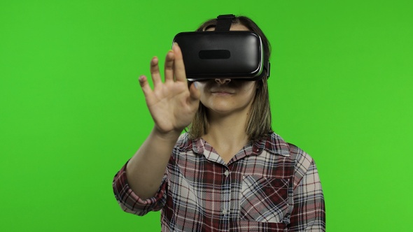 Woman Using VR Headset Helmet To Play Game. Watching Virtual Reality 3d 360 Video. Presses Buttons