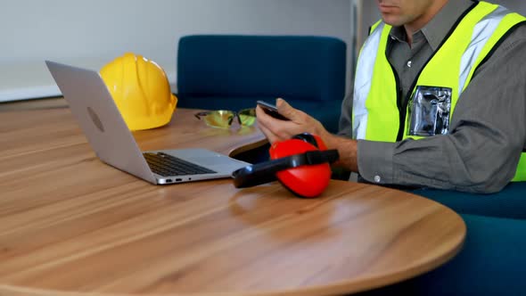 Male worker using mobile phone at desk 4k