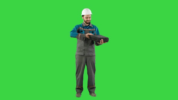 Handyman Prepared for Any Eventuality Shows Tools on Camera on a Green Screen, Chroma Key.