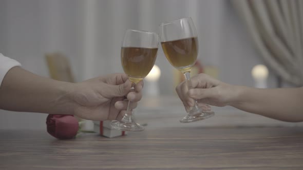 Close up romantic couple clink champagne or wine toast in a dinner at restaurant