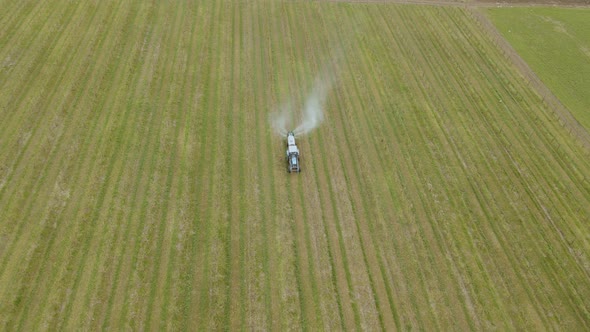Aerial View of a Farming Tractor Driving Spraying on Orchard Apple Fruit Garden with Sprayer