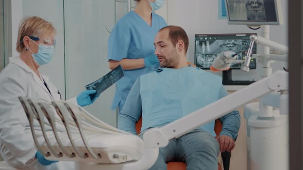 Stomatologist Showing x Ray Scan Diagnosis to Patient