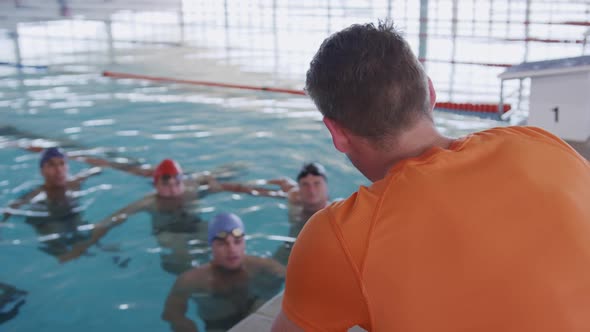 Swimming coach talking to swimmers