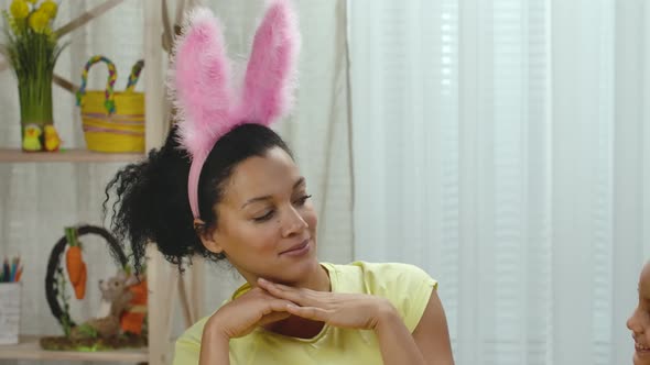 Mom Tries on Her Daughter Funny Pink Bunny Ears and Laughs Merrily
