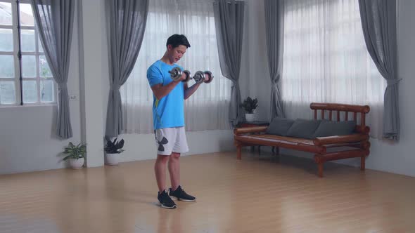 Young Asian Man Doing Exercises With Dumbbells At Home