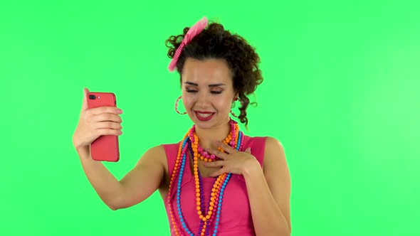 Smiling Girl Talking for Video Chat Using Mobile Phone and Rejoice on Green Screen