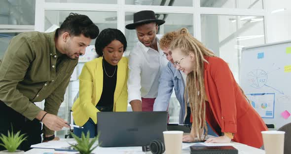 Team which Checking Details on Joint Business Project on Computer in Office Room