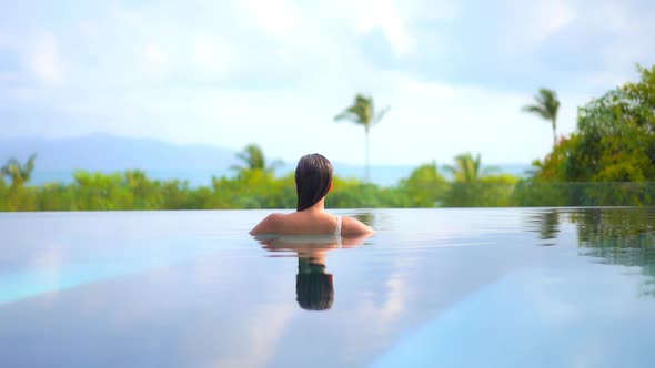 Young asian woman enjoy around outdoor swimming pool for leisure