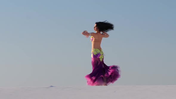 Dancer Performs Sexual Movements with Her Body Against the Blue Sky Background