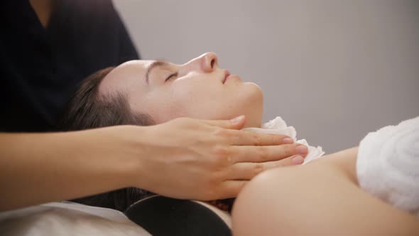 Face Massage  the Massagist Wiping Face of Her Female Client Before the Procedure