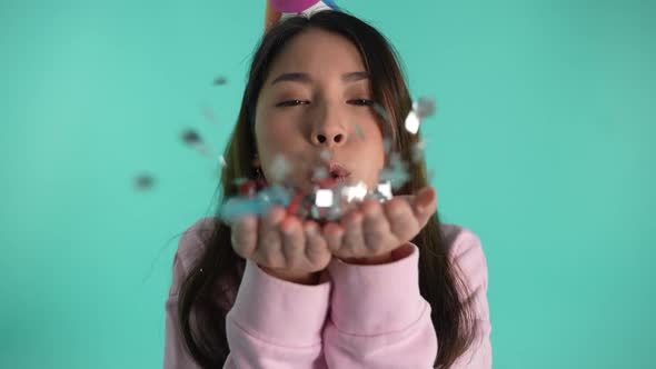 Joyful Asian Female Blowing Glitter on Birthday