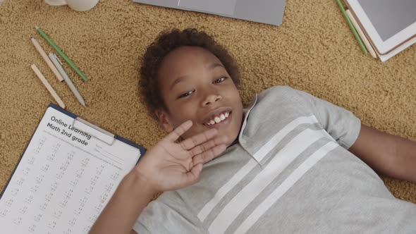 African Boy on Floor Waving Hand