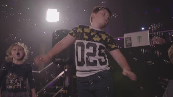 Young Boy Dancing at Party Whilst Bubbles are Blown All Around Him - Ungraded