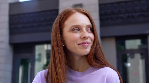 Close-up of Face of Happy Redhead Lady Looking Around Outdoors on Bright Sunny Day