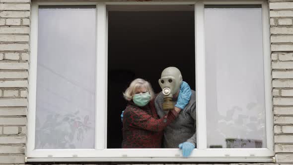 Old Grandparents Stay at Window Isolated at Home on Quarantine. Coronavirus