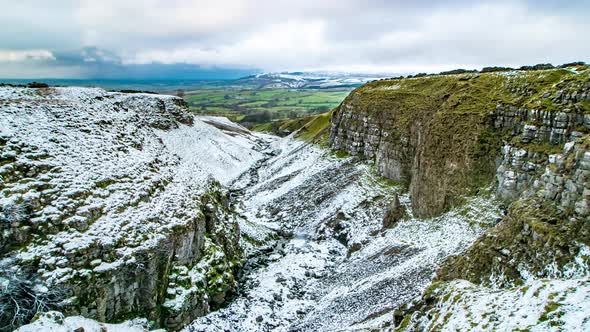 Looking down Mousegill as a snow shower approaches in the upper Eden Valley in Cumbria UK. With pan