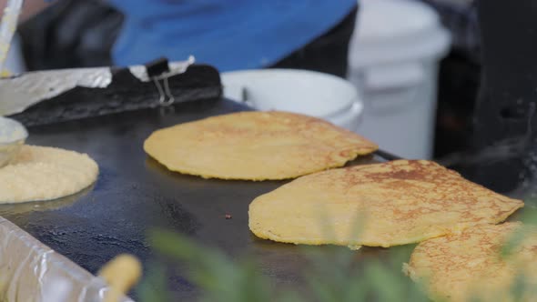 Woman Frying Tortilla Wraps on Frying Pan in the Kitchen