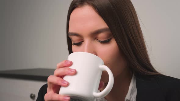 Portrait of Satisfied Businesswoman Drinking Tea at Home Office