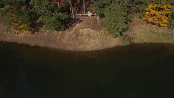 Aerial Drone Footage of Man and Woman Hikers Sdanding on Shore of Famous Mountain Lake Synevir in