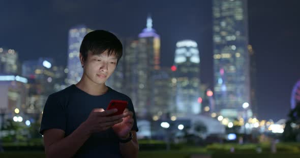 Man use of mobile phone in city at night