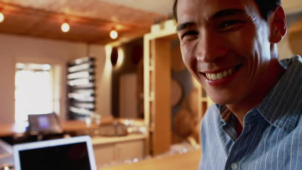 Smiling man holding a glass of beer in restaurant 4k