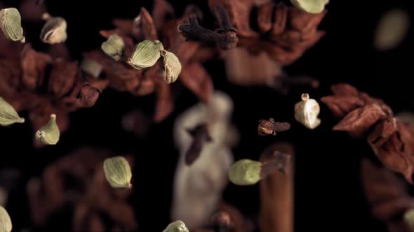 Super Slow Motion Shot of Flying Tea Mix Spices in Black Background