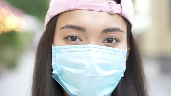 Asian woman standing at the street, wearing medical