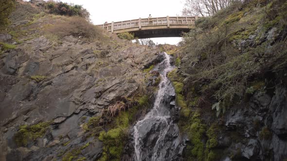 Revealing shot of small waterfall in Victoria park, Vancouver