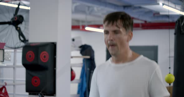 Legs of Male Boxer with Skipping Rope. Fighter Doing Jump Rope Exercises in Dark Gym with Smoke in