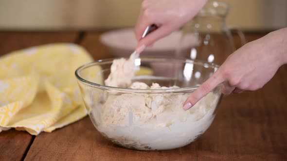 Female preparing and knead the dough in bowl