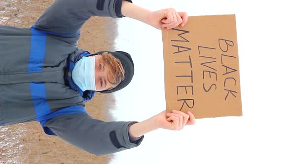 A Caucasian Man Holding a Sign with the Words BLACK LIVES MATTER