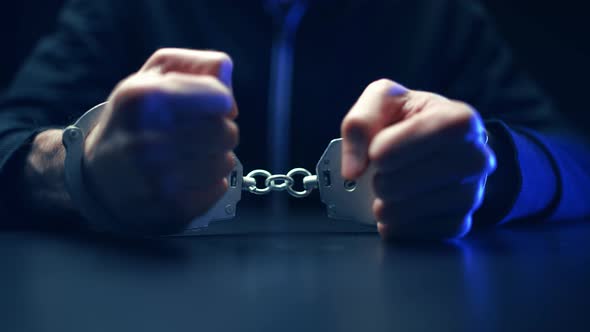 Arrested Criminal Man in Handcuffs in the Interrogation Room