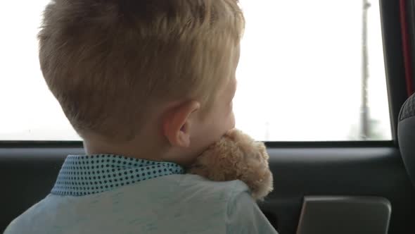 Child traveling in car with favourite teddy bear