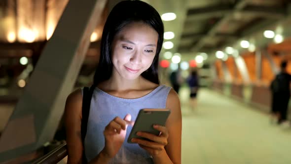 Woman using mobile phone at night 