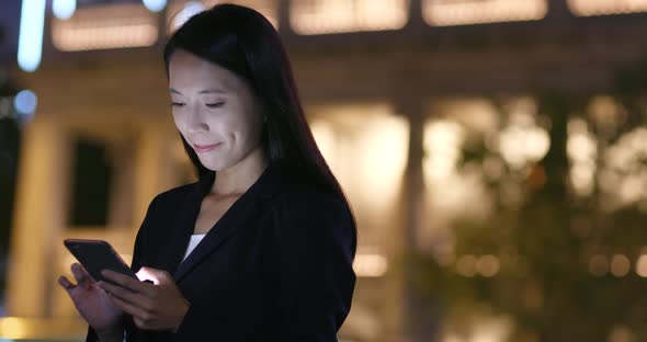 Woman Looking at Mobile Phone in City 